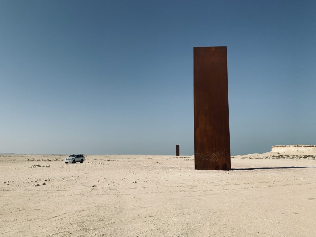 Qatar horizon with large vertical steel structure by Richard Serra.