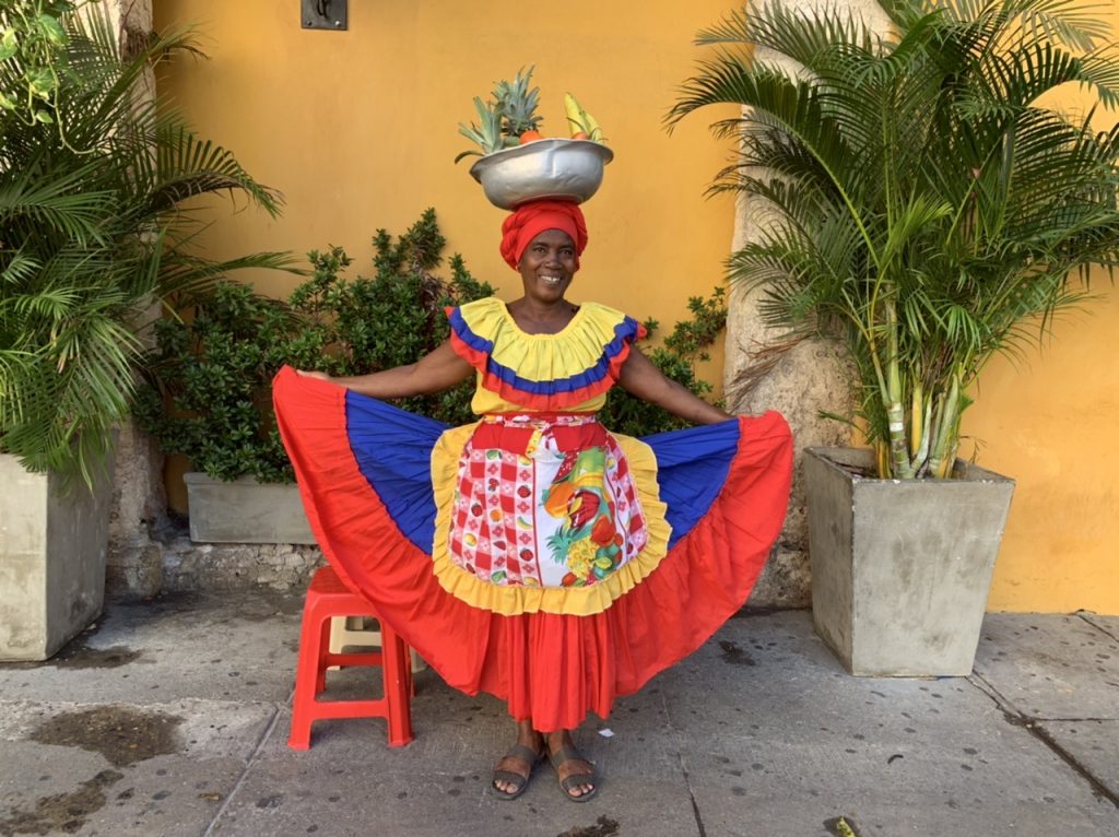 Colombian woman in a bright yellow, red, and blue dress