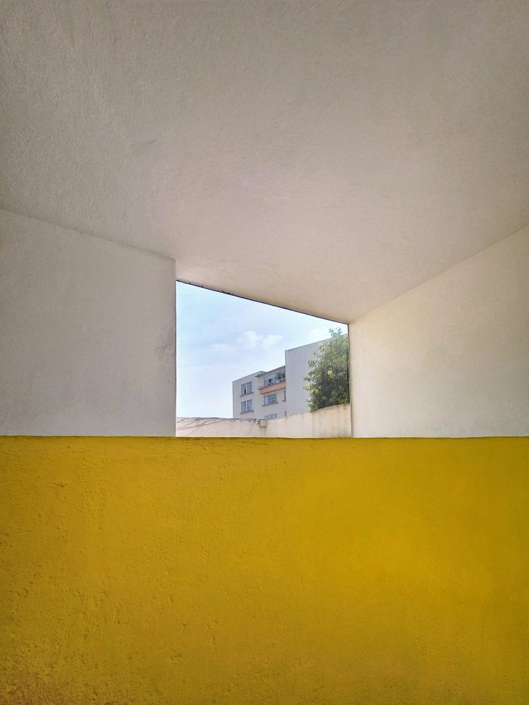 Framing the environment with architecture. A yellow wall meets the outside. 