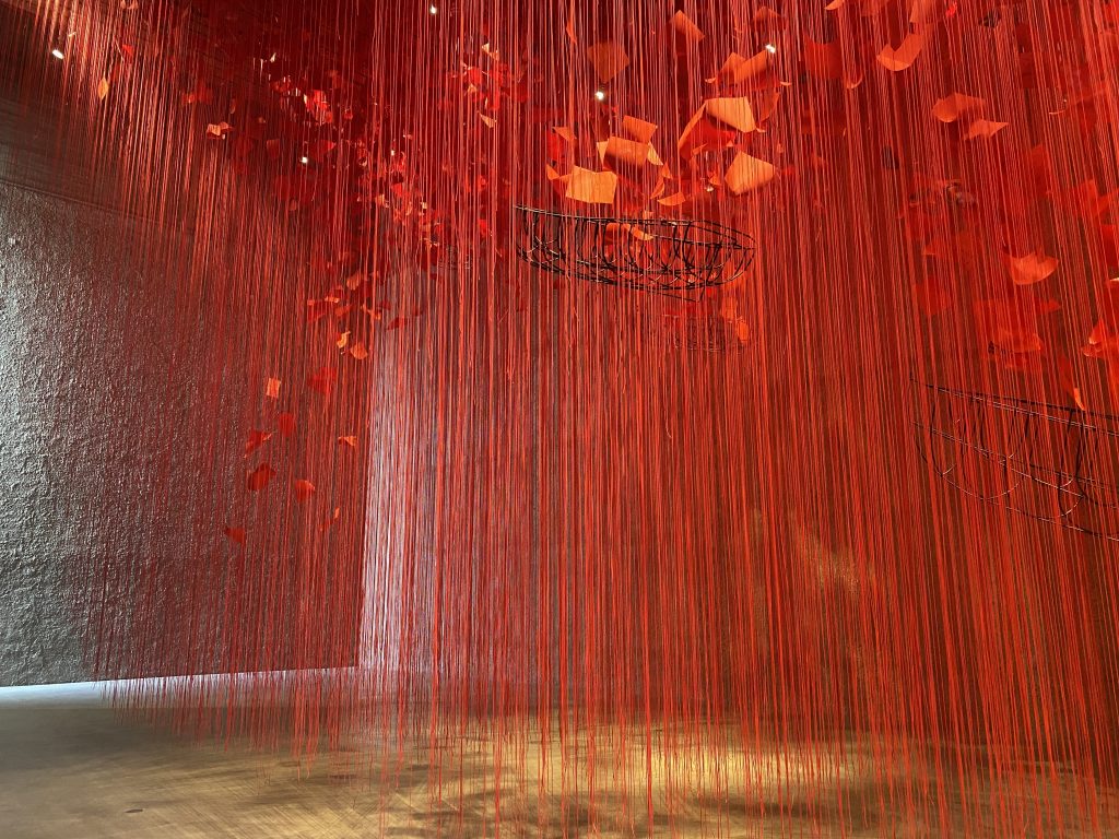 Red threads from the ceiling at the "I hope" Chiharu Shiota exhibition in Berlin.